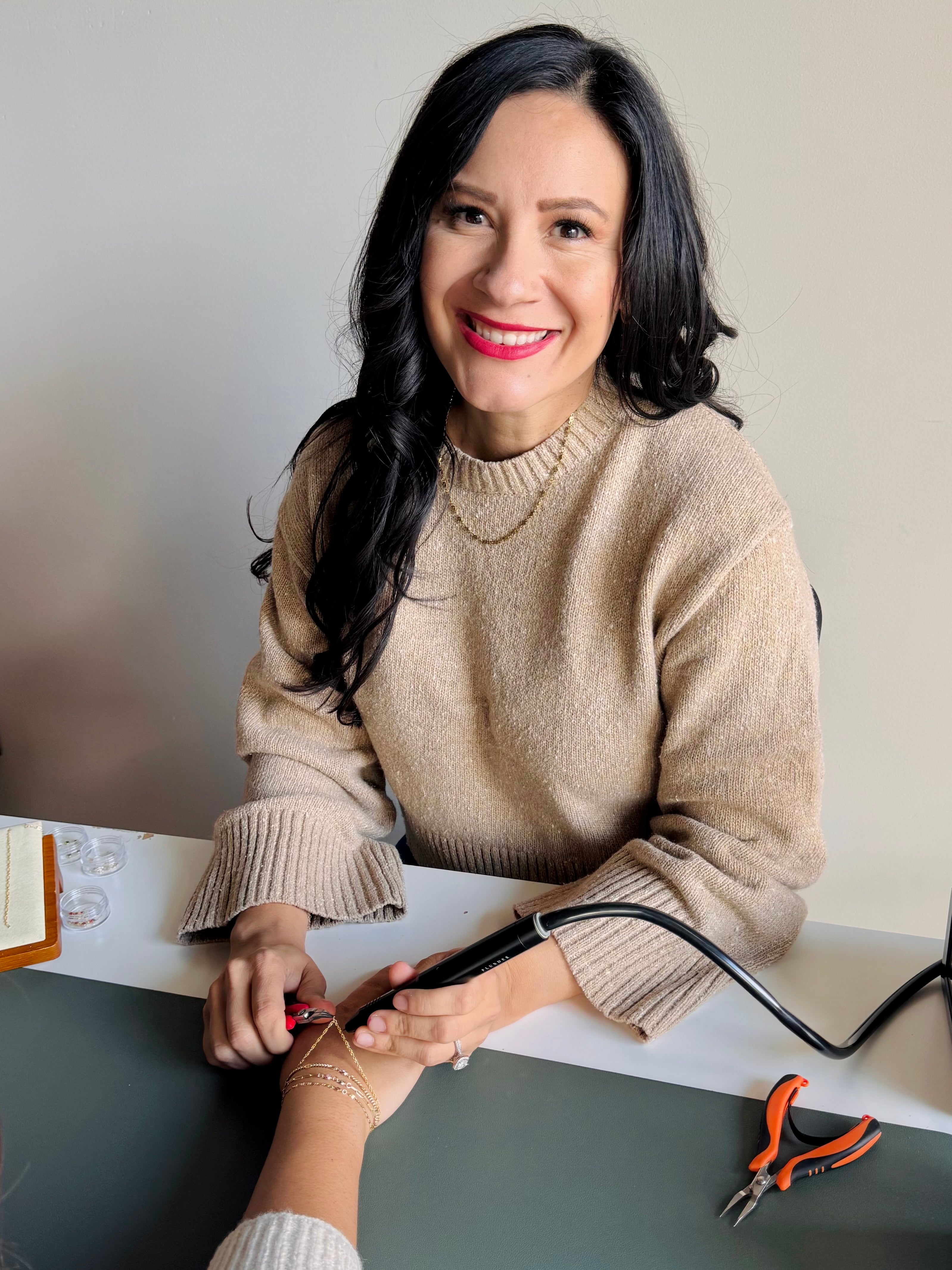 27 West team member welding permanent jewelry at an on-site event