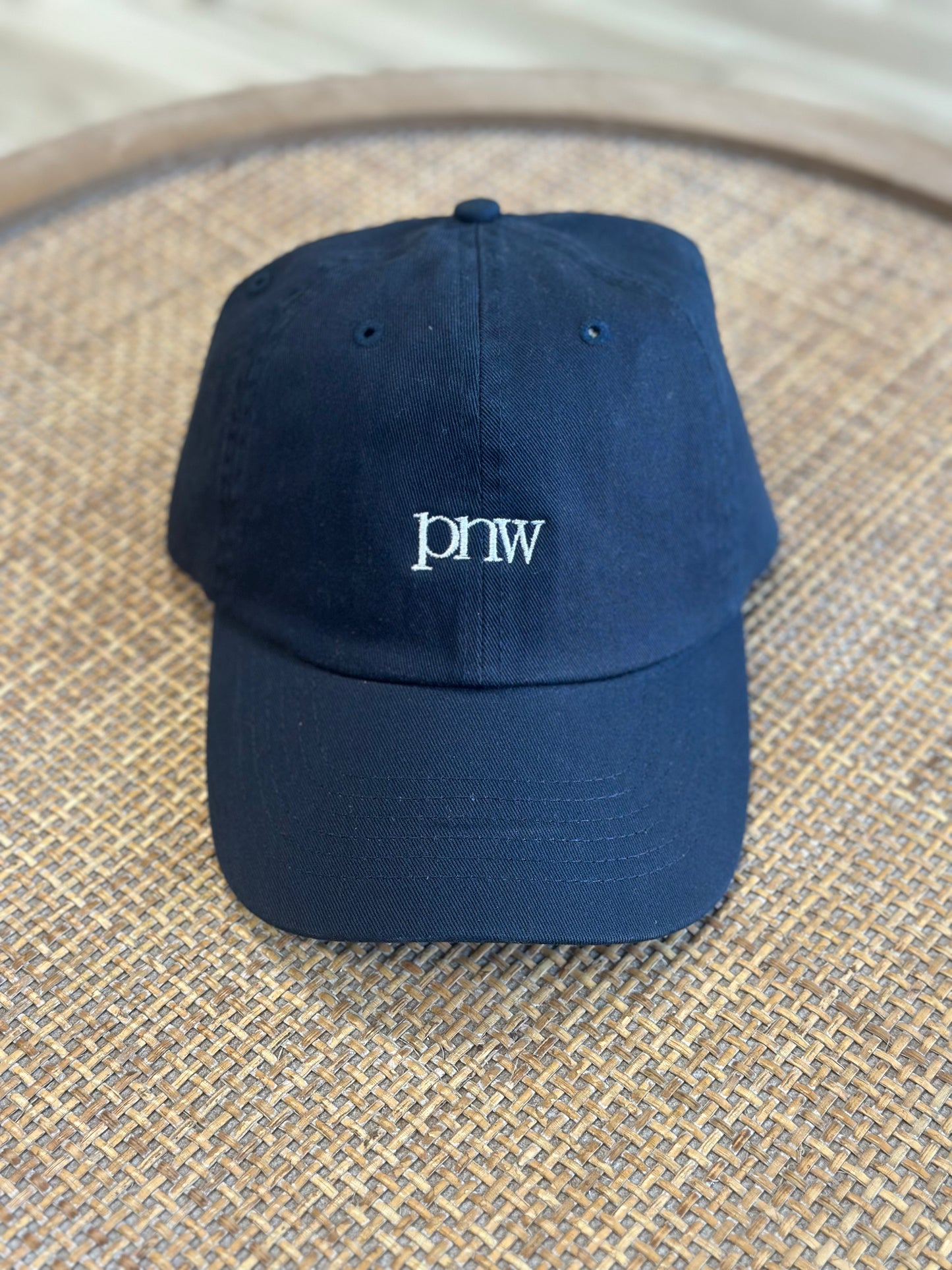 Front view of navy PNW Dad Hat with embroidered PNW design