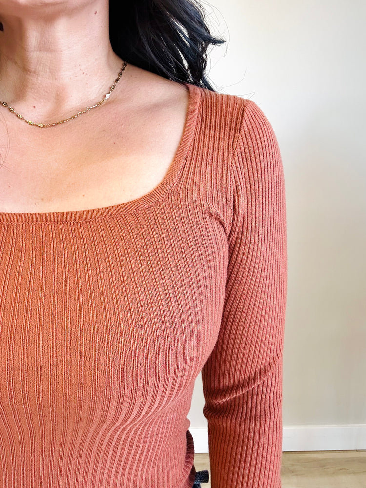 Close-up of rust-colored fabric and square neckline of Allison top