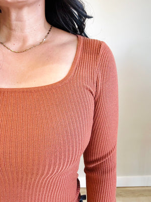Close-up of rust-colored fabric and square neckline of Allison top