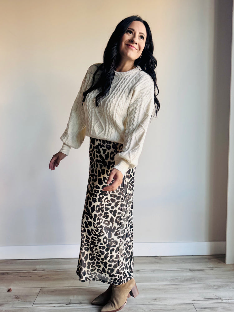 Side profile of cable knit sweater showing relaxed fit and soft knit detailing