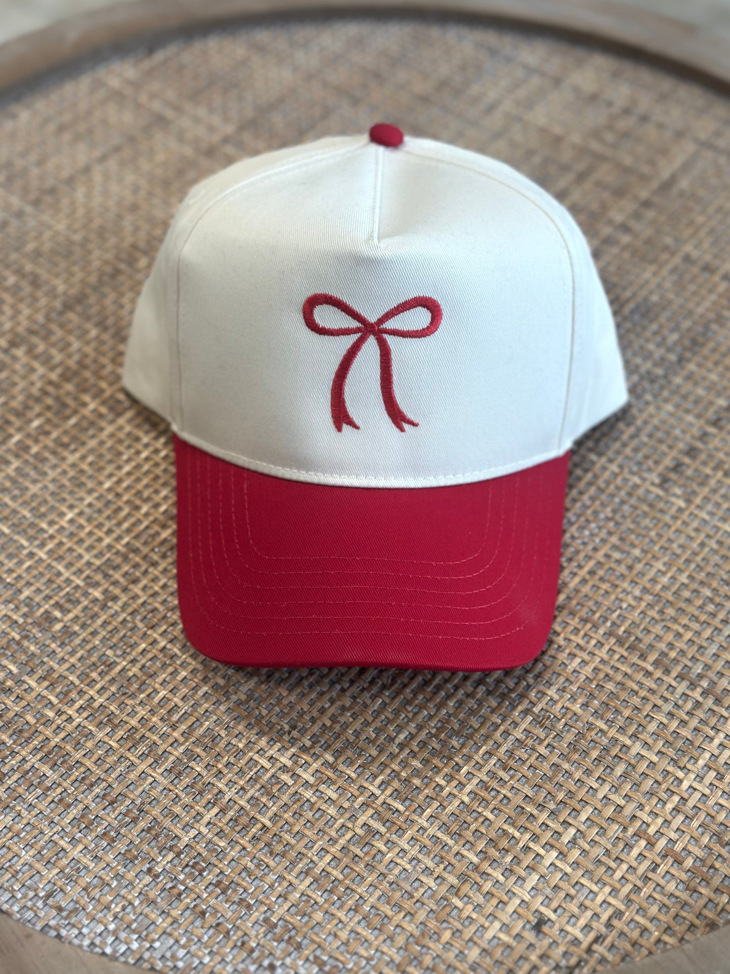 Front view of two‑toned hat with embroidered bow design