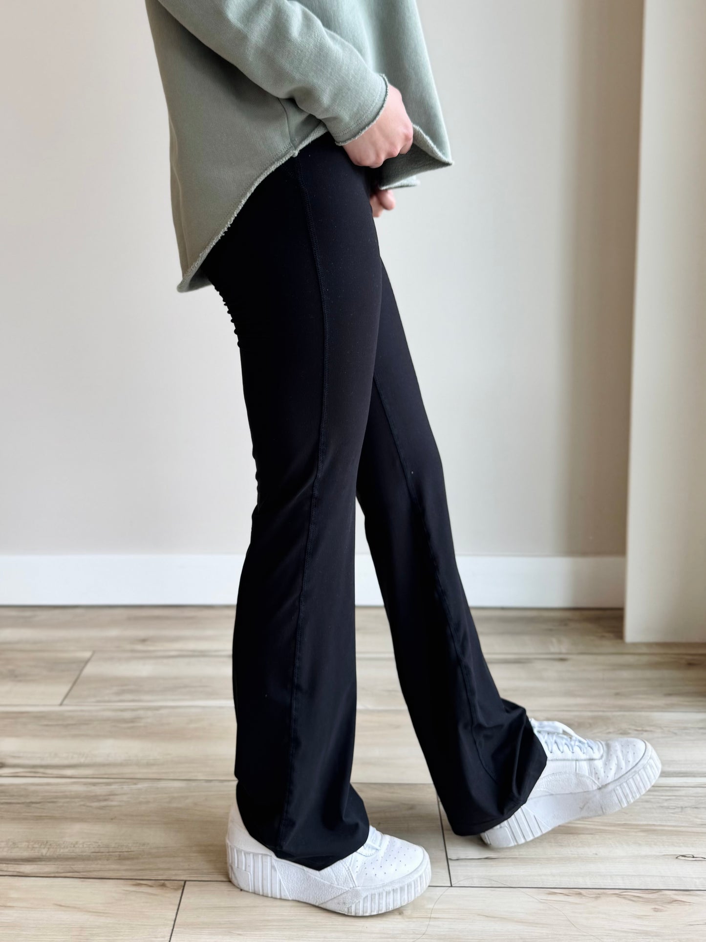 Side profile of Butter Soft Flared Leggings in Black, highlighting flattering fit and soft fabric.