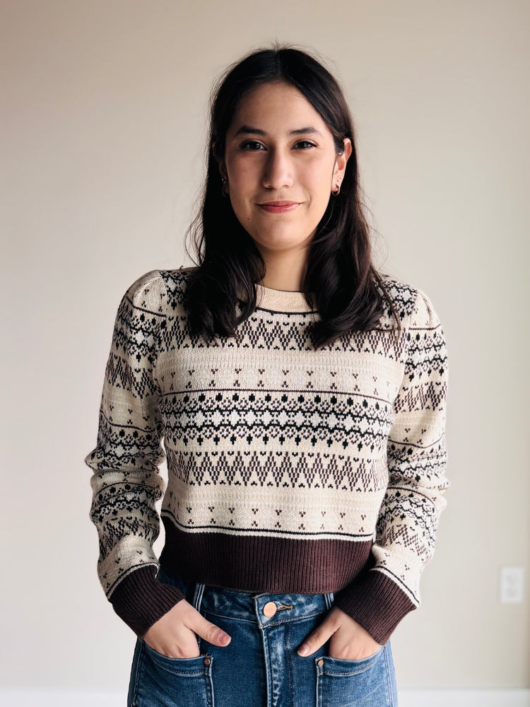 Side angle of cropped fair isle sweater showing puff sleeve and ribbed hem detail
