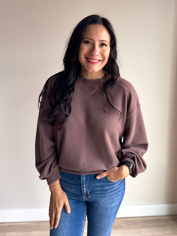 Side angle of Chrissy crewneck top in mocha showing soft knit texture and hip-length hem