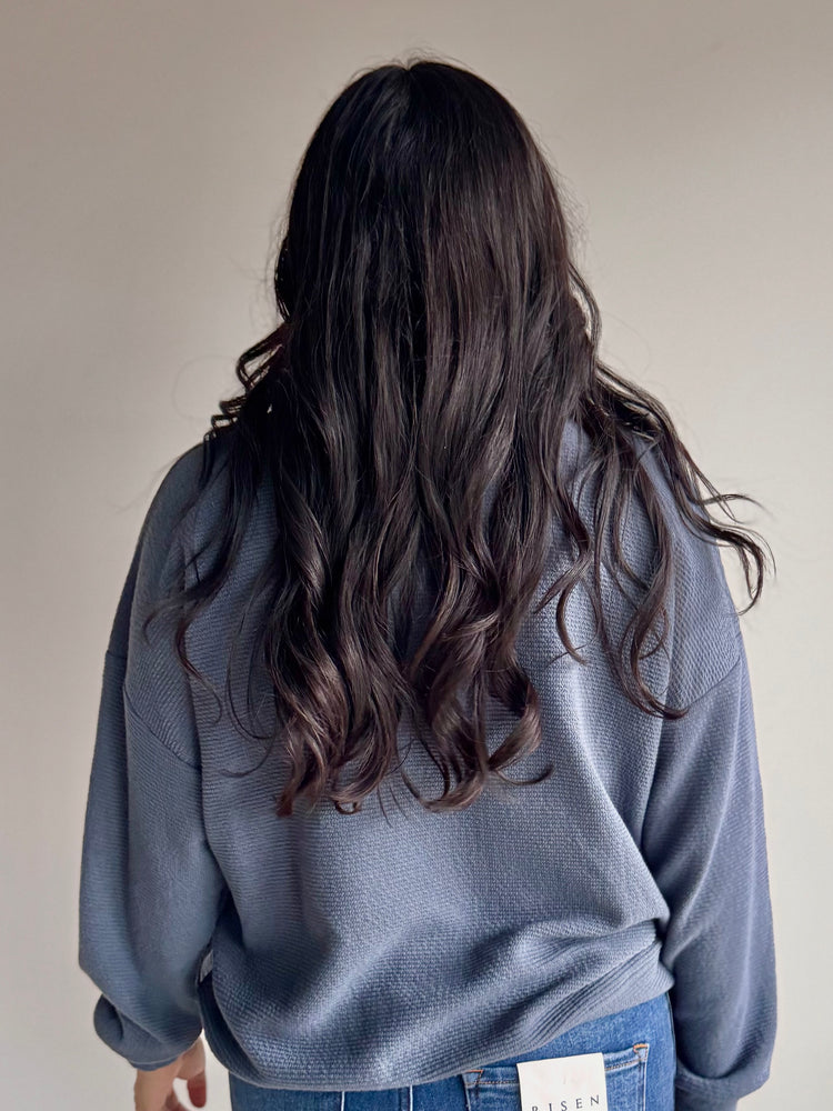 Back view of Laurel knit top in slate blue with long sleeves and breathable fabric