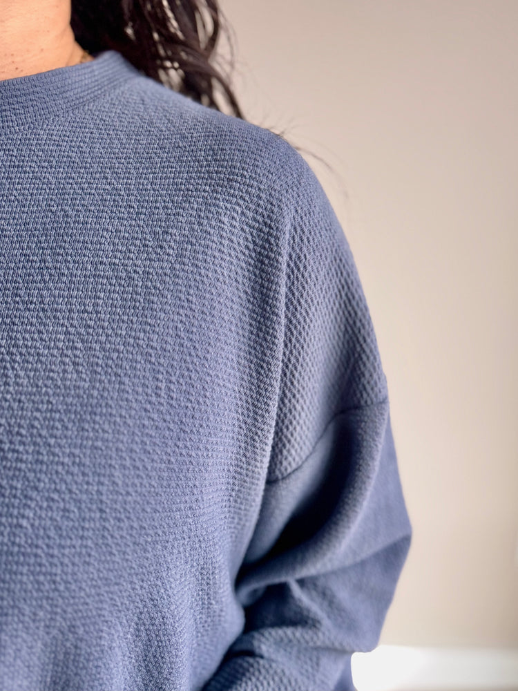 Close-up of cloudy knit texture and ribbed neckline on Laurel slate blue top