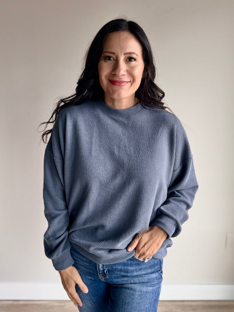 Front view of Laurel knit top in slate blue with round neckline and relaxed silhouette