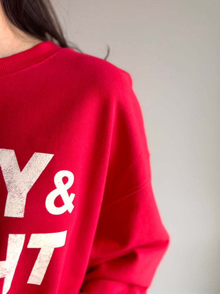 Close-up of Merry & Bright graphic and ribbed neckline on holiday sweatshirt