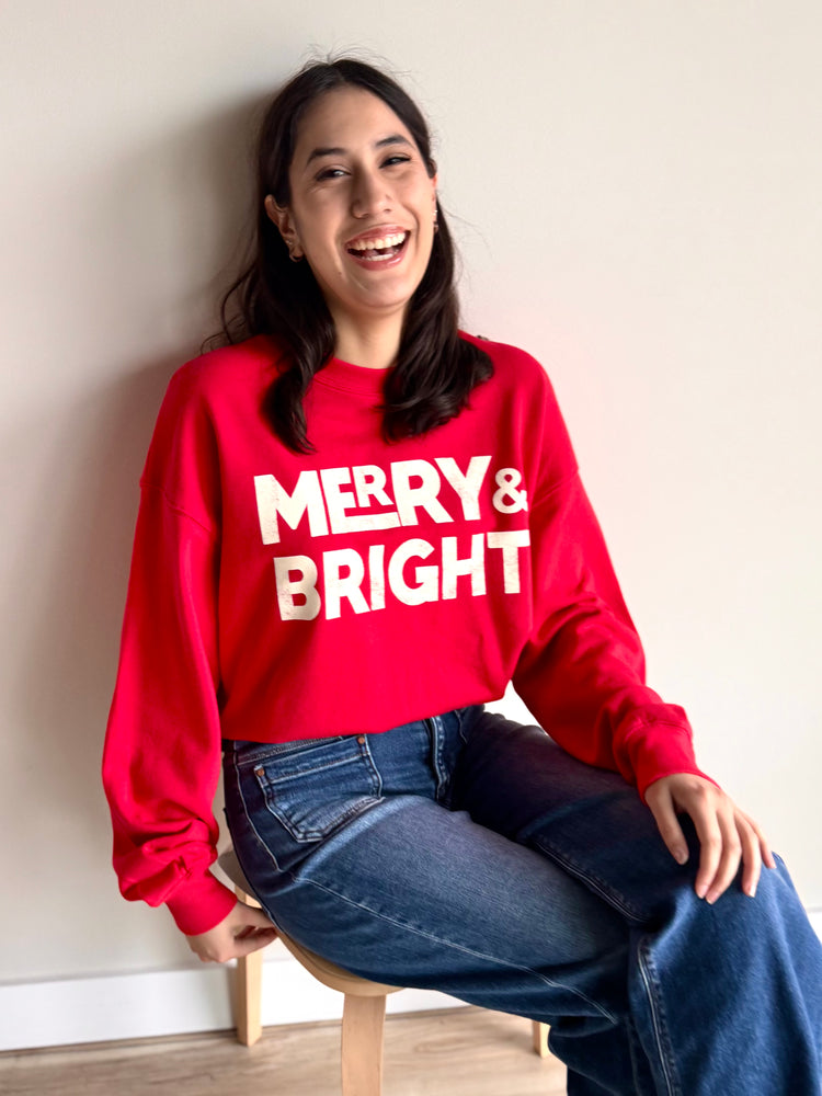 Front view of red and white Merry & Bright crewneck sweatshirt with festive graphic