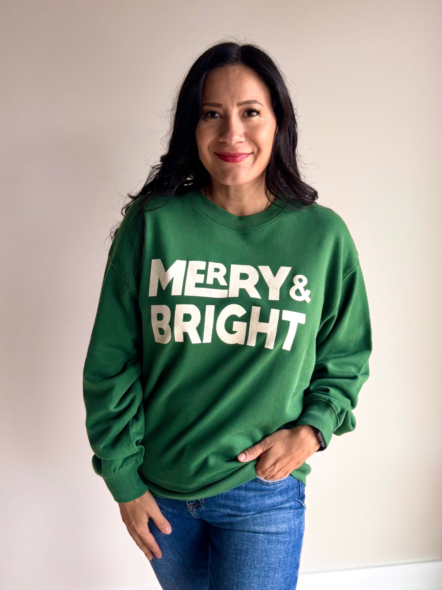 Front view of green and white Merry & Bright crewneck with bold holiday graphic and relaxed fit