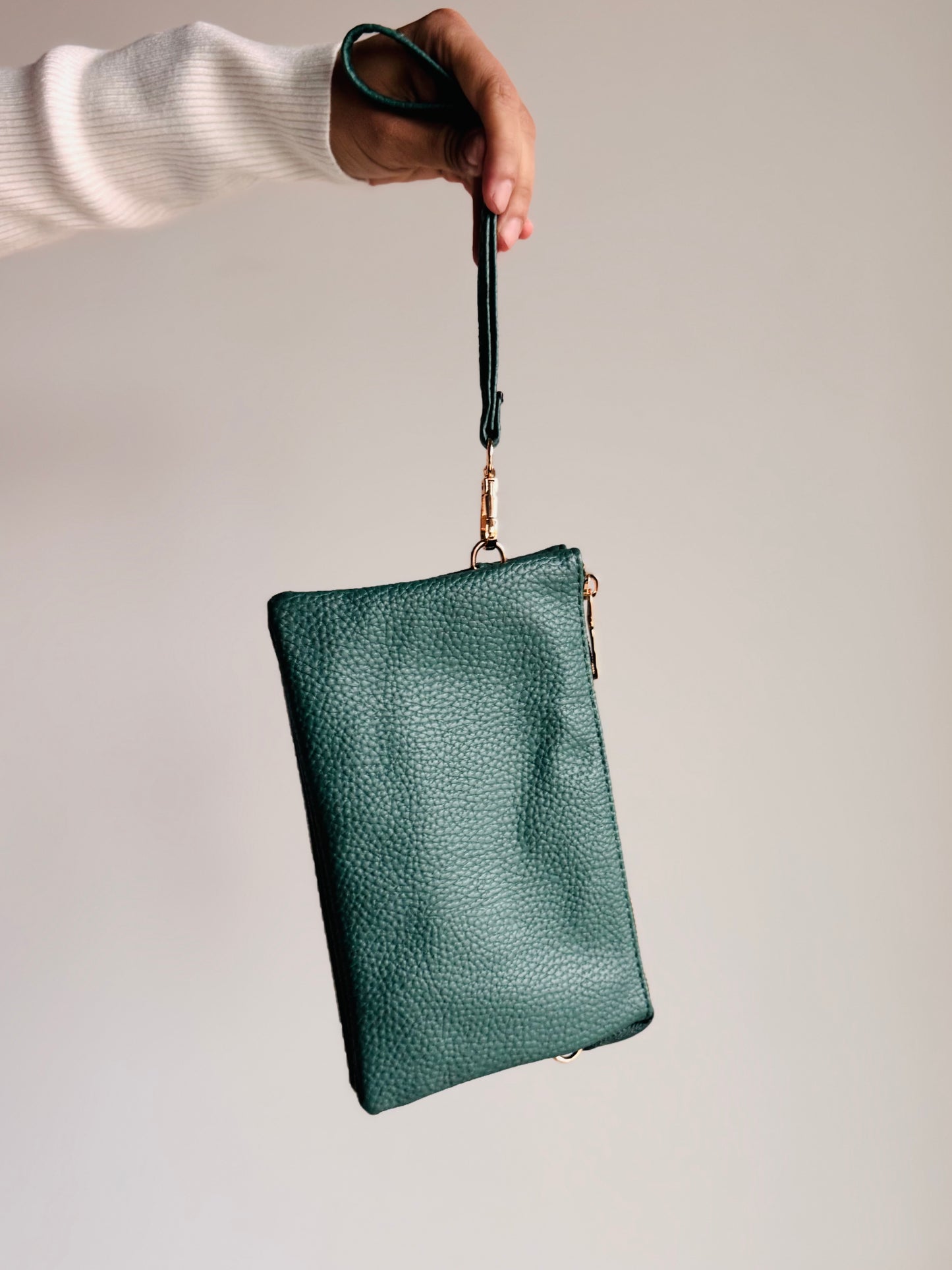 Forest green Sedona purse with gold zipper and medallion emblem shown from front view