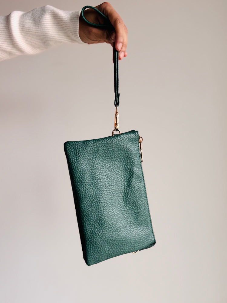 Forest green Sedona purse with gold zipper and medallion emblem shown from front view