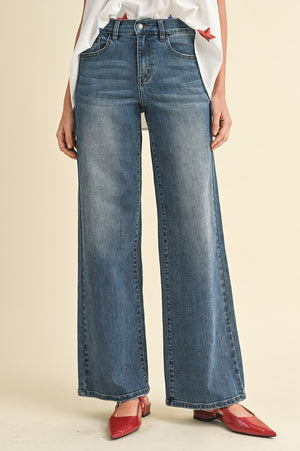 Model wearing Shay High Rise Wide Leg Denim in a casual setting, demonstrating versatility.